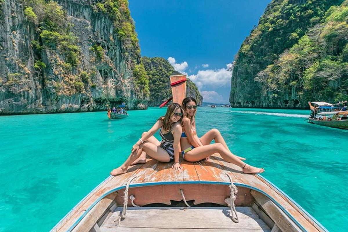 a couple sitting on the back of a boat in the water