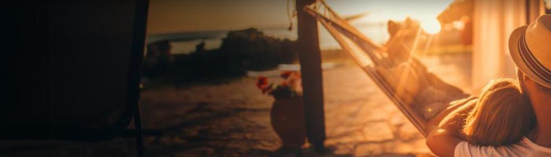 Un padre y su hija juntos en una hamaca viendo un precioso amanecer