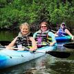three women are kayaking on a river