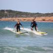 two men riding a wave on surfboards in the water