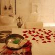 a room with red petals on a table with a bowl and a pile