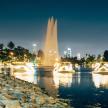 a fountain in the water with a city in the background