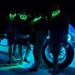 a group of people standing around a motorcycle with neon lights