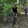 two people riding bikes down a dirt trail