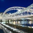 a large white bridge over water at night