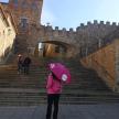 a woman with a pink umbrella standing in front of some stairs