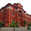 a large red building with trees in front of it