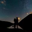 a man and a woman standing under a starry sky