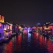 a view of a canal at night with colorful lights