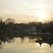 a sunset over a lake with a pagoda in the distance