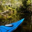 a blue kayak sitting in the middle of a river