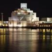 a building at night with water in front of it