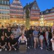eine Gruppe von Menschen, die in einer Stadt für ein Foto posieren