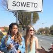 a group of women standing next to a street sign
