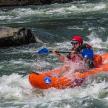 a man in an orange kayak in a river