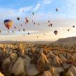 a group of hot air balloons flying over rocks
