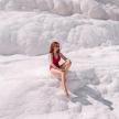 a woman in a red bikini sitting on the snow