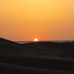 a sunset in the desert with the sun in the horizon