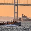 a boat with people on it in the water near a bridge