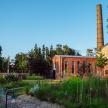 an old brick building with a chimney in a garden