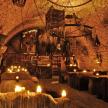 a room with candles and tables in a cave