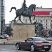 a car driving past a statue of a man riding a horse