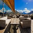 a patio with couches and tables and a view of mountains