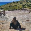 a woman sitting on the steps of an amphitheater