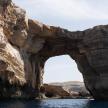 an arch in a rock formation in the water
