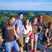 a group of people posing for a picture in front of chocolate hills