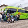 a group of people standing in front of a green bus