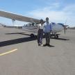 a man and woman standing in front of a small plane