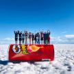 a group of people standing on a snowboard in the snow