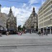 a city street with buildings and people walking around