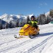 a person sitting on a snowmobile in the snow