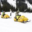 a group of people riding on a snowmobile in the snow