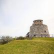 a lighthouse sitting on top of a grassy hill
