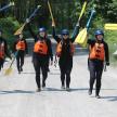 a group of women walking down a road holding paddles
