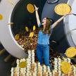 a woman is standing on a pile of gold coins