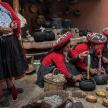 a group of women in traditional clothing preparing food
