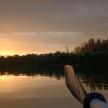 a person paddling a boat on a lake at sunset