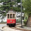 a red and white trolley car on the tracks