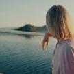 a young girl standing on a boat near the water