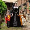 a man and two children dressed in costumes walking down a street