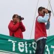 two men taking pictures with binoculars on a boat