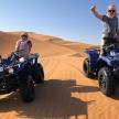 dva lidé jedoucí na čtyřkolkách v poušti