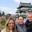 three women are standing in front of a building