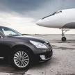 a black car is parked next to an airplane