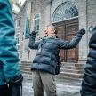 一位老妇人站在一栋建筑前