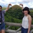 two girls standing on a fence with their arms in the air